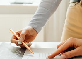 pexels-photo-7681094-7681094 Close-up of hands reviewing financial documents and graphs in an office setting.